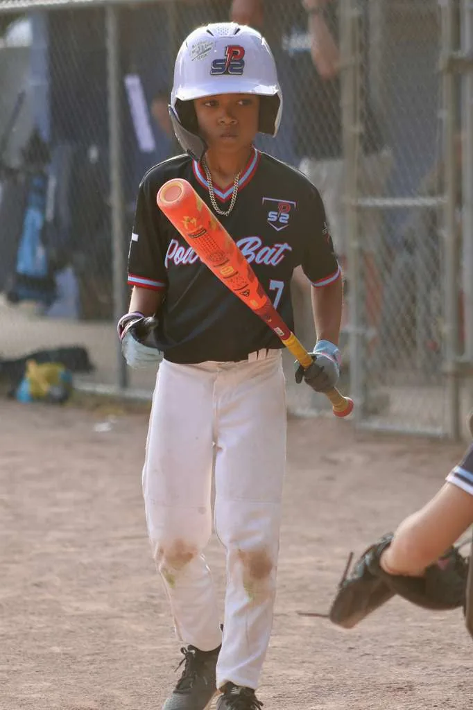 Young batter walking to the plate